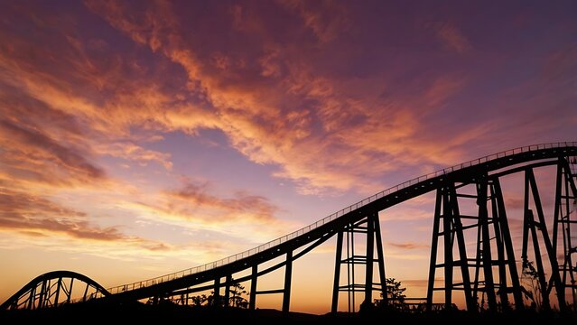 Roller coaster silhouette against a dramatic sunset sky with vibrant orange and purple clouds in amusement park