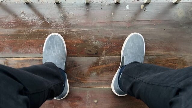 First-Person Point of View of Anxious Leg Tapping on a Wet Patio Floor