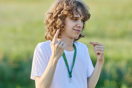 Young man with sunflower lanyard signing in outdoor field