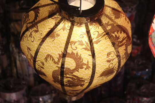 Traditional yellow lantern with dragon illustration pattern for asian festivals.