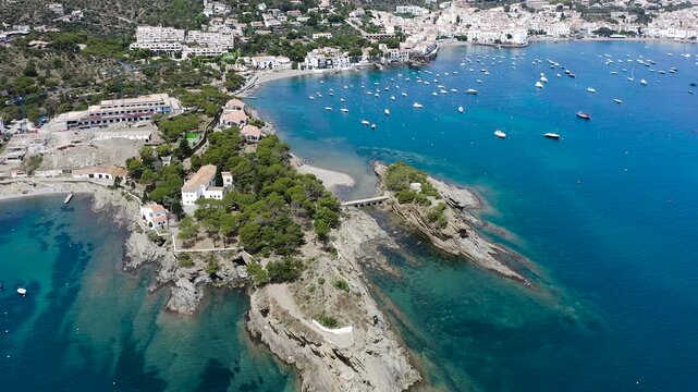 Aerial view of the picturesque fishing village of Cadaqu&eacute;s, featuring its whitewashed houses, historic waterfront, peaceful harbor and the crystal-clear waters of the Mediterranean on the Costa Brava.