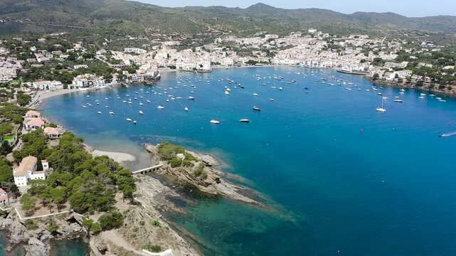 Aerial view of the picturesque fishing village of Cadaqu&eacute;s, featuring its whitewashed houses, historic waterfront, peaceful harbor and the crystal-clear waters of the Mediterranean on the Costa Brava.