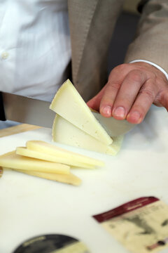 chef cortando queso con un cuchillo para degustar