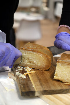 quesero cortando una cu&ntilde;a de queso de oveja curado artesanal