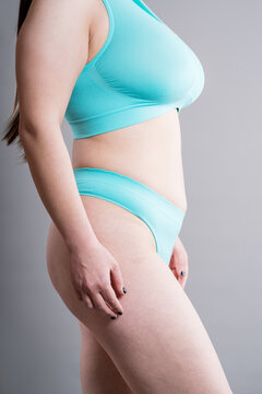 Unrecognizable curvy woman with saggy breasts in comfortable seamless blue underwear. Real body, body positivity and self-acceptance concept