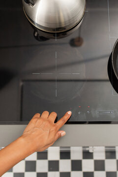 Overhead close up of turning on induction cooktop with cast iron skillet