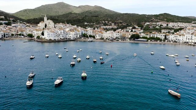 Aerial view of the picturesque fishing village of Cadaqu&eacute;s, featuring its whitewashed houses, historic waterfront, peaceful harbor and the crystal-clear waters of the Mediterranean on the Costa Brava.