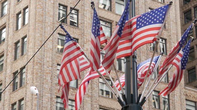 American flags near Grand Central Terminal on 42 street, New York City, Manhattan Midtown. Urban building architecture in United States. Typical offices windows of brick tower. Pershing square in NYC.