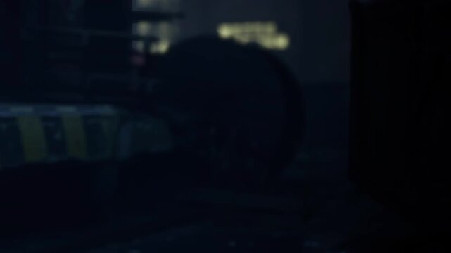 A city street scene at night shows dim light reflecting off buildings and shadows. The environment feels quiet and deserted. There is also a large object partially visible.