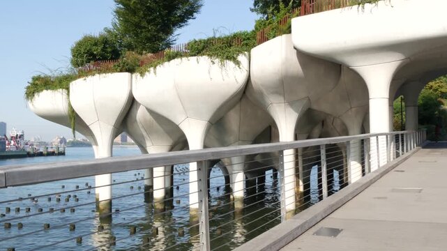 New York City Little Island pier park, oasis in Manhattan Midtown, United States. Urban architecture on pillars in Chelsea, USA. Futuristic contemporary concrete columns design, Hudson river landmark.