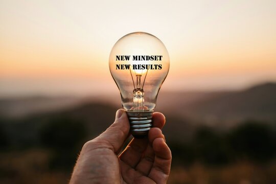 Hand holding a light bulb with new mindset new results text