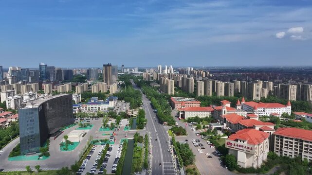 Rizhao city main avenue flanked by modern buildings and green spaces under clear blue sky