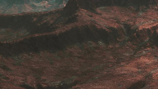 Rugged terrain features rocky slopes and patches of vegetation. Hills rise in the background. The setting is dry with red and brown earth, suggesting a remote location.
