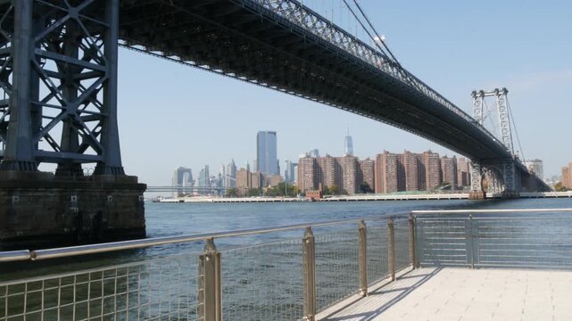 Williamsburg Bridge in Brooklyn, New York City, United States. Transport metallic bridge near Marcy Av subway station and Domino park in Williamsburg. World Trade Center skyscraper tower on Manhattan.