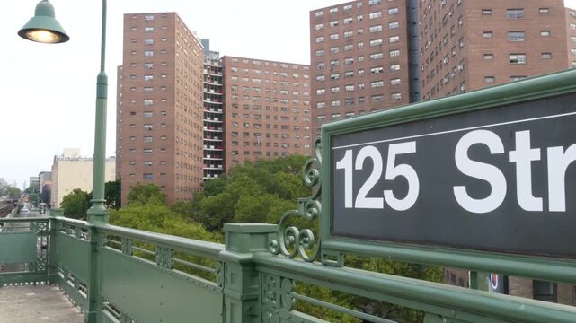 New York City Upper Manhattan subway outdoor station platform, 125 street sign, elevated metro in Harlem, United States railway. Residential district public metropolitan transport. Apartment houses.