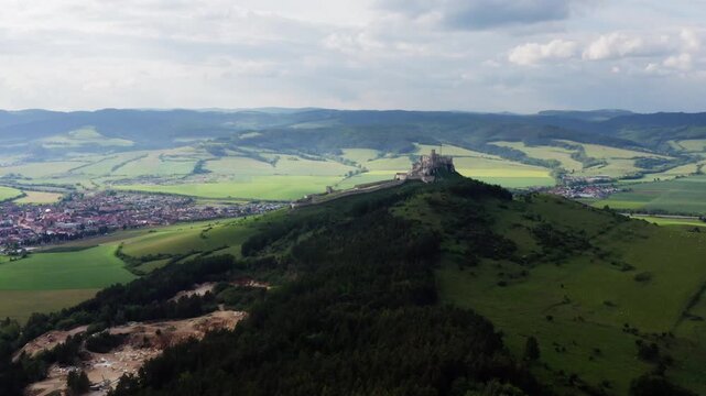 Aerial 4K drone video of Spi&scaron; Castle, a UNESCO World Heritage site, with High Tatras mountain range in background. Scenic Slovak landscape, medieval fortress, and travel concept