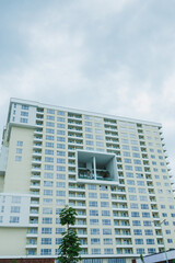 Fototapeta premium Building stands tall with many windows showing modern design in an urban area during cloudy weather