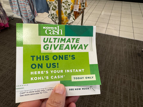 Mesa, Arizona - June 27, 2026: Hand holds a Kohls cash coupon giveaway in a Kohls department store