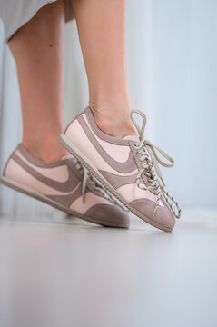 nike sneakers standing on light-colored indoor floor in casual relaxed setting with suede and leather materials and pink beige tones in low angle view for fashion lifestyle.