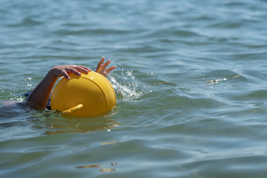 Small child underwater trying to reach a rescue buoy in open water. Powerful concept of drowning prevention, water safety education and accident awareness.