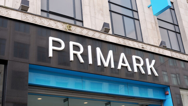 Manchester, England, UK - 18 June 2026: Primark storefront sign, white corporate logo lettering on dark marble facade with blue trim, high street fashion retail shop