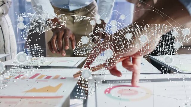 Business team tapping target chart on glass table, causing dotted map overlay tracking pointing