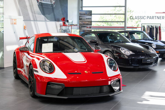 Roost Bissen, Luxembourg - June 22nd 2026 : View on a red Porsche 992 GT3 finished in Indian red in a showroom with other Porsches behind.