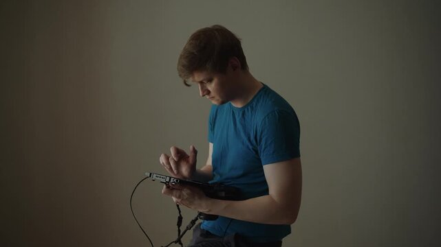 Professional technician using specialized portable device for work, intently focused on screen and adjusting settings, concept of sign of concentration, slight frustration. Shooting in slow motion