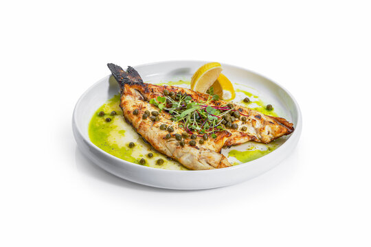 Grilled Mediterranean Branzino Fillet with Caper Sauce and Lemon Garnish