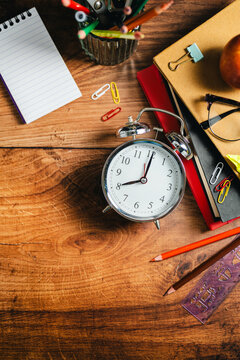 Back to school concept. School desk flat lay with stationery and alarm clock, copy space background banner