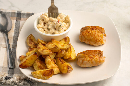 chicken thighs  with   potatoe wedges and  macaroni salad
