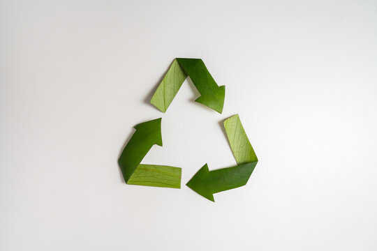 Recycling symbol made from green leaves on white background, environmental sustainability concept