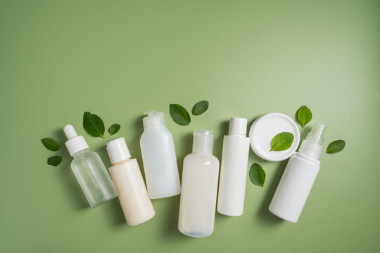 Natural skincare products with botanical leaves on green background, clean beauty cosmetic collection mockup