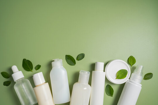 Natural skincare products with botanical leaves on green background, clean beauty cosmetic collection mockup