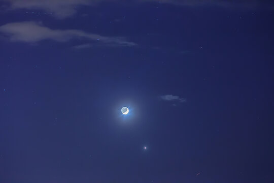Night sky with crescent moon, stars, bright Venus and satellites