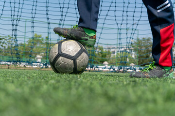 Football player controlling a soccer ball during training on an outdoor sports field. © May