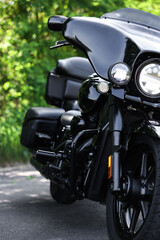 Fototapeta premium Modern black motorcycle parked on road outdoors, closeup