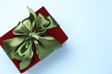 Fototapeta premium Beautiful velvet gift box on light blue background, top view. Space for text