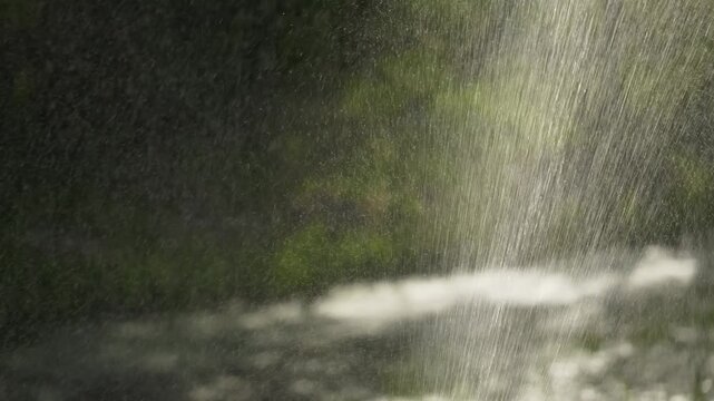 Jet of sprayed water creating misty stream in slow motion