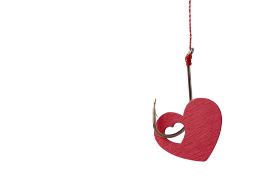 Red heart shape on a sharp fishing hook isolated on white background. Conceptual marketing bait, love trap and relationship risk banner with clear copy space.