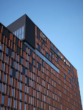 Vertical view of Brama Miasta office facade with Wella Company, GFT and BFF signage on April 12, 2026 in Lodz, Poland