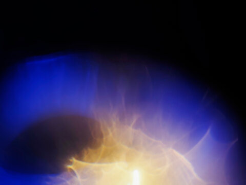 Warm orange and blue light leaks on black. Abstract background for design and special effects. Random shapes and form. Lens flare.