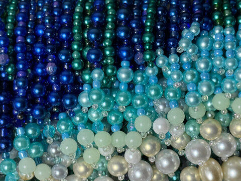 multicolored beads, colored pearl beads in white and blue tones, textured background