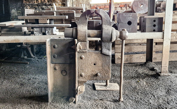 Old metal bench vise in an industrial workshop
