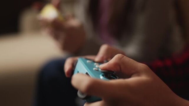 Teenage boy and his mother pressing gamepad buttons while playing video games