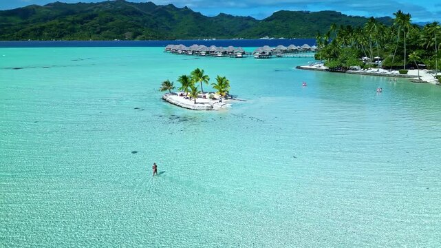 Woman stand up paddle boarding in bora bora lagoon