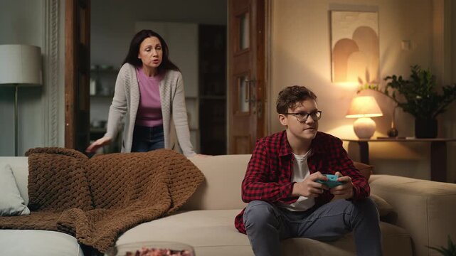 Mother reprimanding her teenage son for excessive video gaming, family conflict