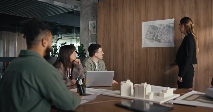 Team members share thoughts and ideas on plans while reviewing designs in a bright office room