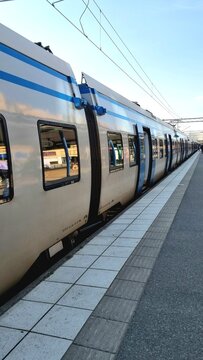 Electric intercity train at Solna station. The long train features a sleek design with a silver and blue color scheme. Large windows line the sides, providing clear exterior reflections. 