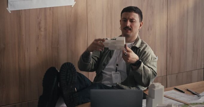 Man opening takeout meal at a desk in a modern office